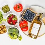 Ingredientes para una dieta antiinflamatoria menopausia: espinacas, fresas, arándanos, brócoli, tomates, nueces, semillas de calabaza, avena y aceite de oliva.