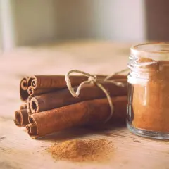 Canela en rama y en polvo en un frasco, destacando sus maravillosas canela propiedades para la salud y la cocina.