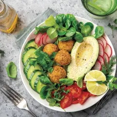 Un plato vibrante con falafel, aguacate, pepino, tomate y rábano, ideal para una dieta flexitariana equilibrada.