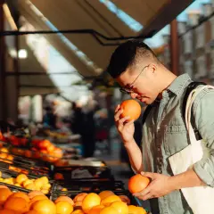 Hombre comprando naranjas, ricas en ácido ascórbico para que sirve: vitamina C para la salud.