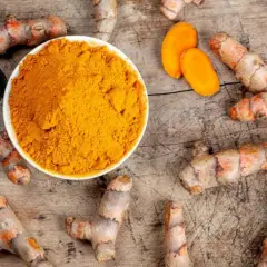 Raíces de cúrcuma y polvo dorado. Descubre para qué sirve la cúrcuma y sus beneficios.