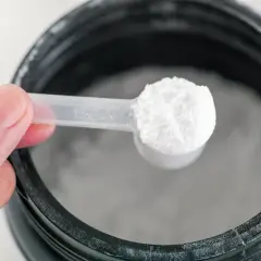 Una cuchara con polvo blanco, posiblemente glutamina para que sirve en la recuperación muscular.
