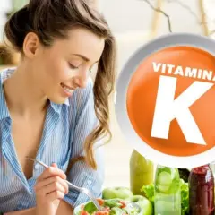 Mujer sonriente comiendo ensalada. El círculo naranja con "VITAMINA K" resalta sus beneficios para la salud.
