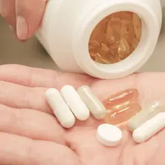 Pastillas en mano, algunas blancas y otras transparentes. Considera las bisglicinato de magnesio contraindicaciones antes de tomarlas.