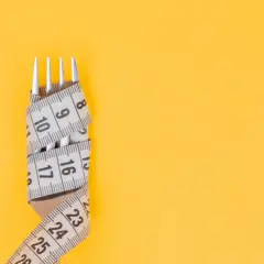Tenedor envuelto en cinta métrica, símbolo de la dieta Pronokal y control de peso.