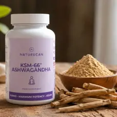 Frasco de KSM-66 Ashwagandha, polvo y raíces en un tazón de madera. Aprende como tomar ashwagandha para tu bienestar.