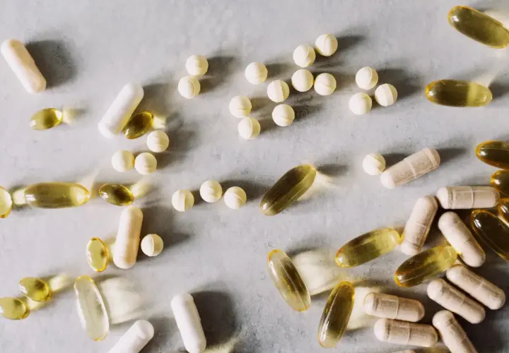 Pastillas y cápsulas de suplementos, algunas amarillas translúcidas, otras blancas y beige. Se investiga para qué sirve la berberina.