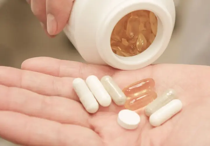 Pastillas en mano, algunas blancas y otras transparentes. Considera las bisglicinato de magnesio contraindicaciones antes de tomarlas.
