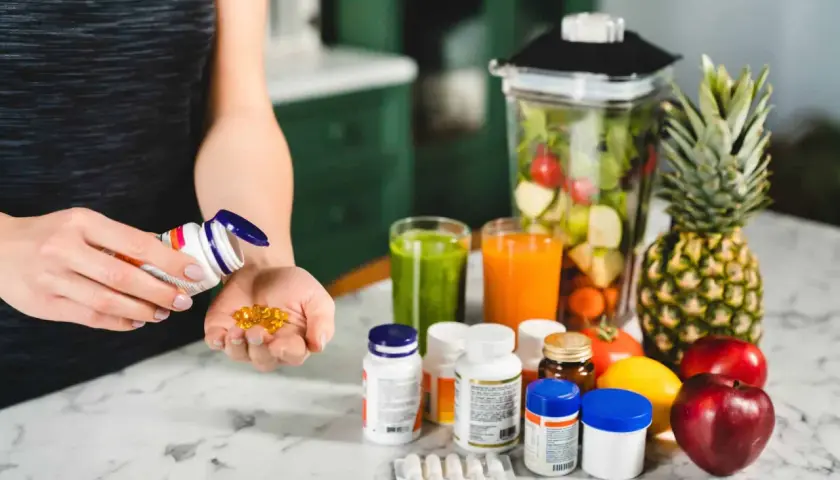 Persona optimiza su salud con biohacking suplementos y batidos de frutas.