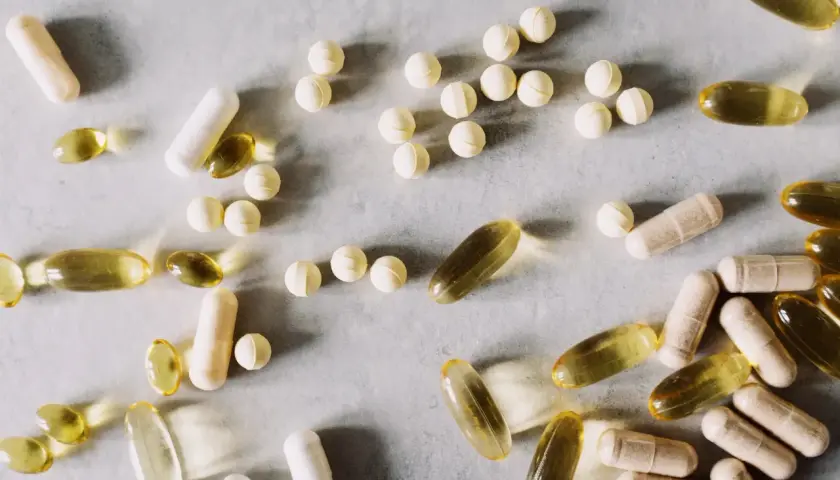 Pastillas y cápsulas de suplementos, algunas amarillas translúcidas, otras blancas y beige. Se investiga para qué sirve la berberina.