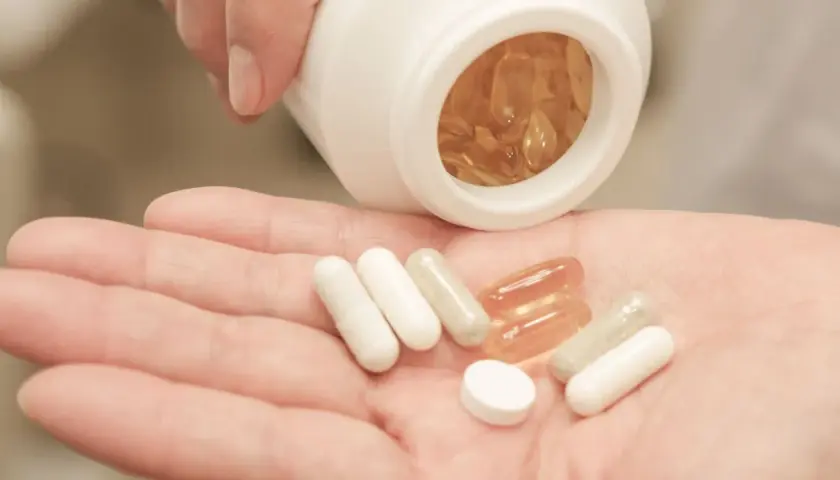 Pastillas en mano, algunas blancas y otras transparentes. Considera las bisglicinato de magnesio contraindicaciones antes de tomarlas.