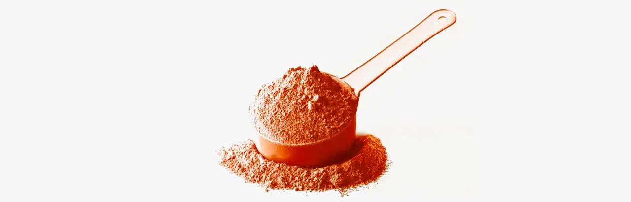Una cuchara naranja llena de polvo de whey, ideal para tus batidos post-entreno.
