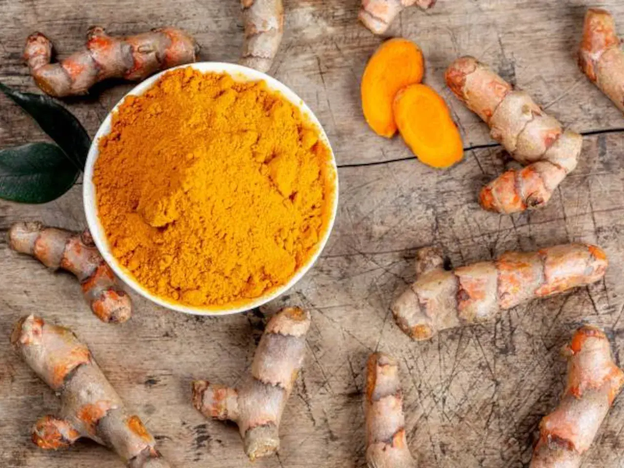 Raíces de cúrcuma y polvo dorado. Descubre para qué sirve la cúrcuma y sus beneficios.