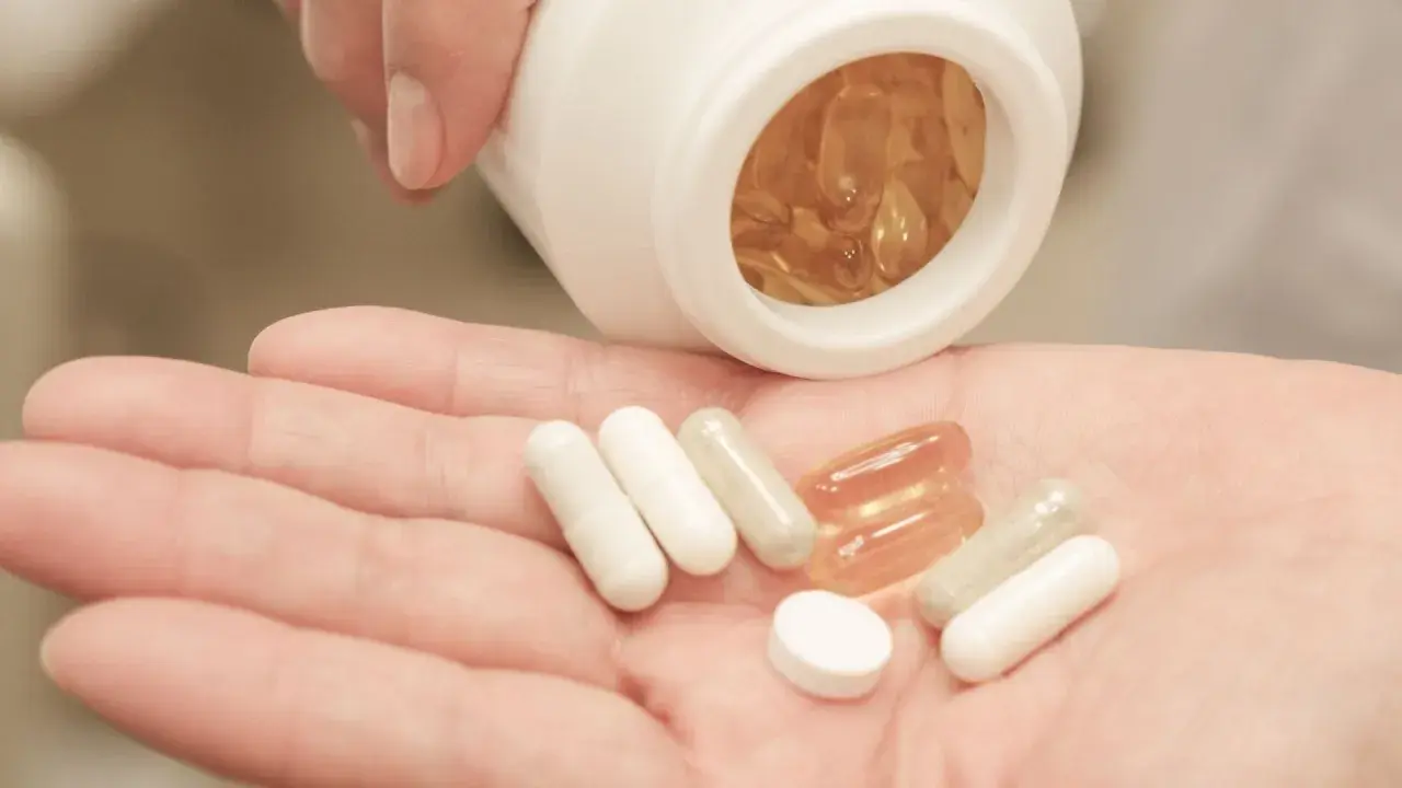 Pastillas en mano, algunas blancas y otras transparentes. Considera las bisglicinato de magnesio contraindicaciones antes de tomarlas.