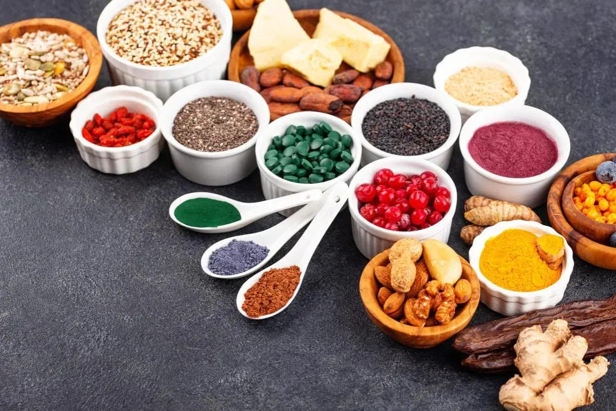 Variedad de alimentos saludables: semillas, bayas, algas, cúrcuma y frutos secos, ideales para una dieta antes de colonoscopia.