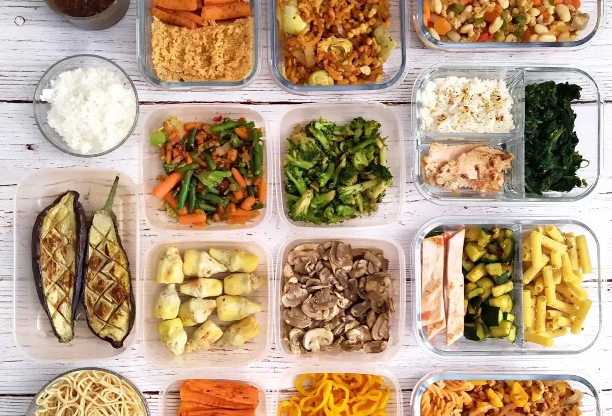 Comida preparada en recipientes para batch cooking: arroz, pollo, verduras, pasta y más.