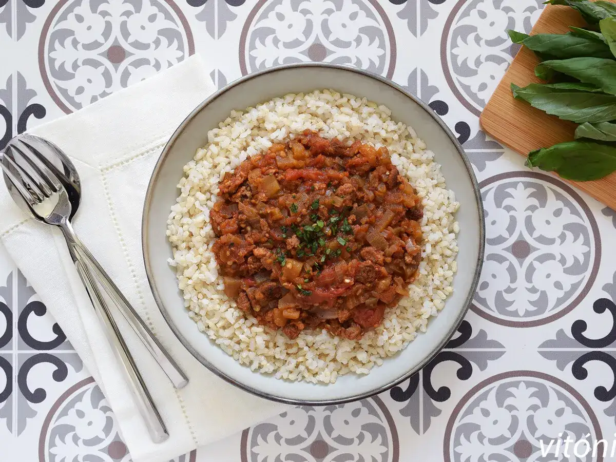 Plato de arroz integral con guiso de soja texturizada, ideal para tus recetas. Cubierto con perejil picado.