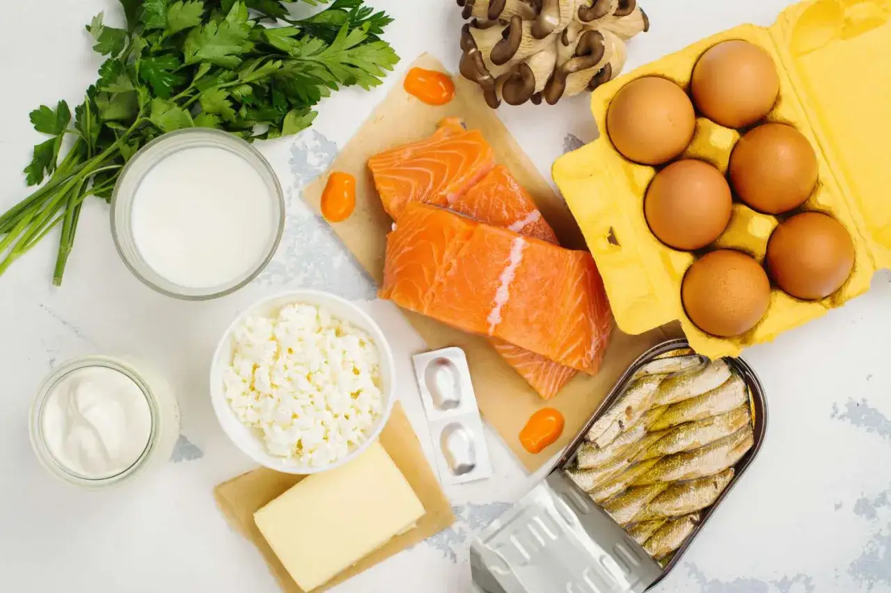 Una variedad de alimentos con vitamina D: salm&oacute;n, sardinas, huevos, leche, queso, mantequilla, champi&ntilde;ones y perejil.