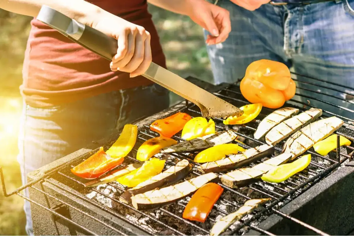 Una deliciosa barbacoa vegetariana con pimientos y berenjenas a la parrilla, bajo el sol.