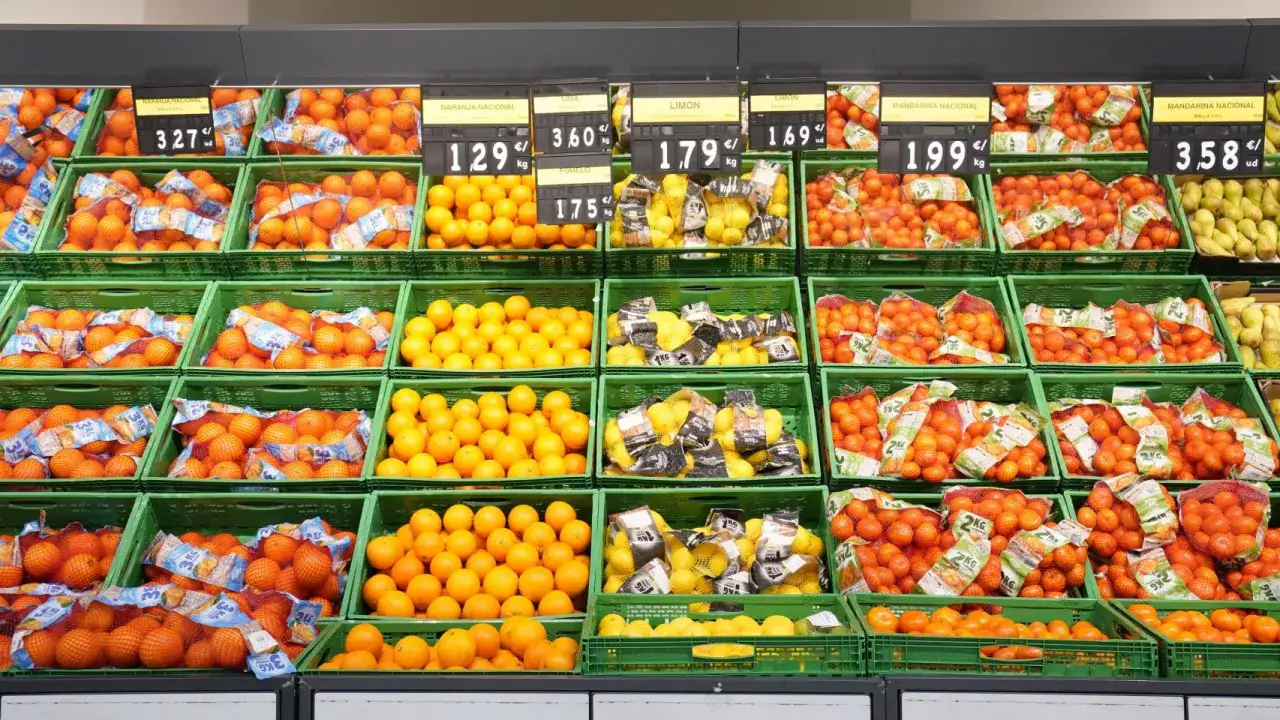 Estanter&iacute;as llenas de naranjas, limones y mandarinas, todas frutas de temporada, listas para ser compradas.