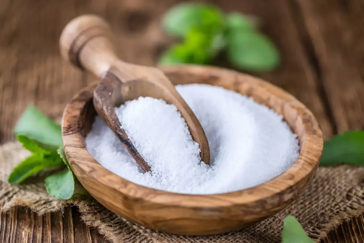 Taz&oacute;n de madera con stevia granulada y cuchara. A pesar de su dulzor, la stevia es mala para la salud.